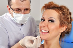 dentist helping patient with her gums